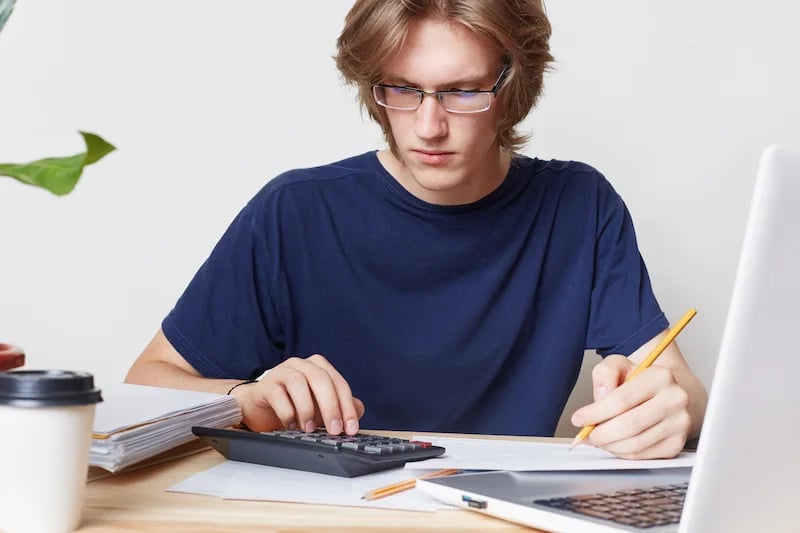 Estudiante de economía haciendo una tarea en la calculadora