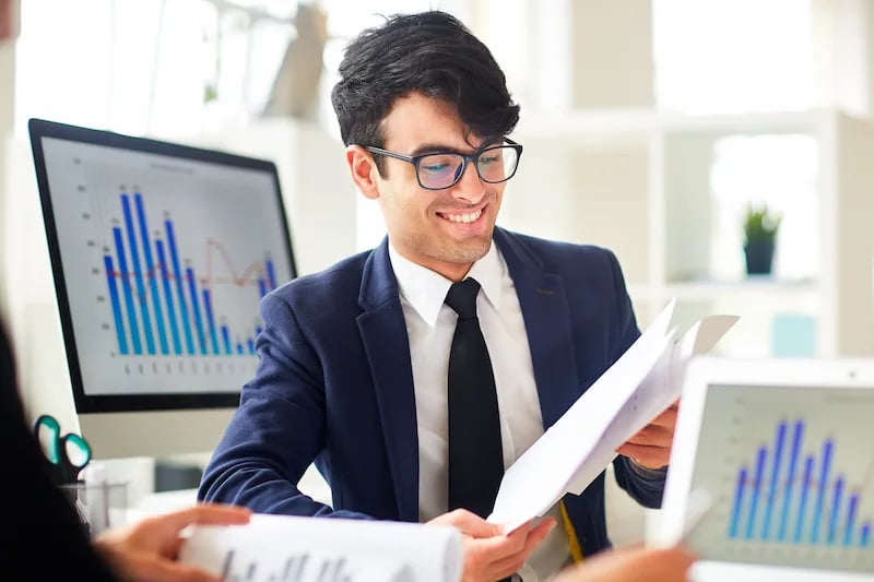 Alumno revisando gráficas de economía en una hoja de papel