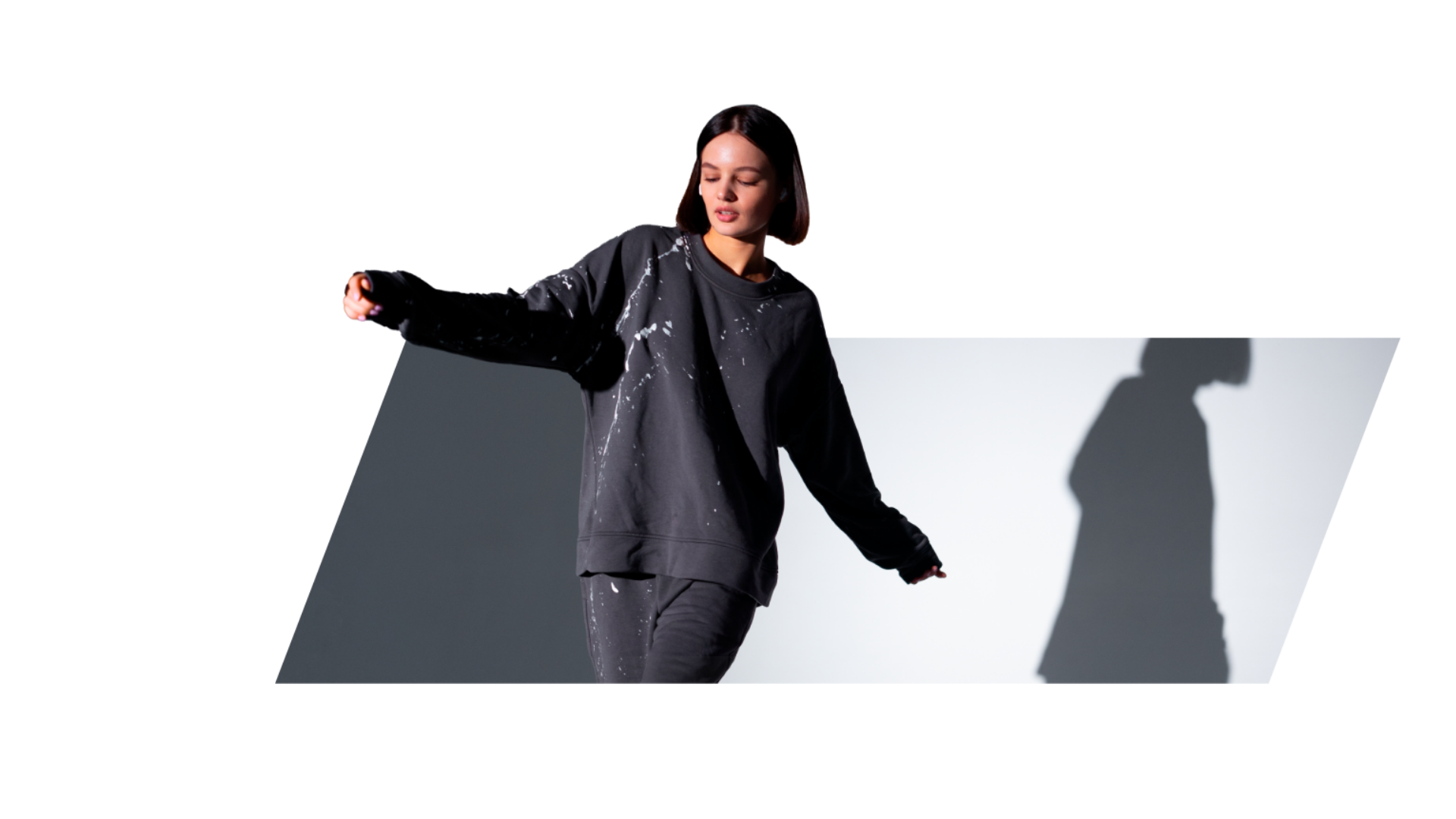 Modelo mujer en una pose de movimiento en un estudio con bloques de luz y sombra