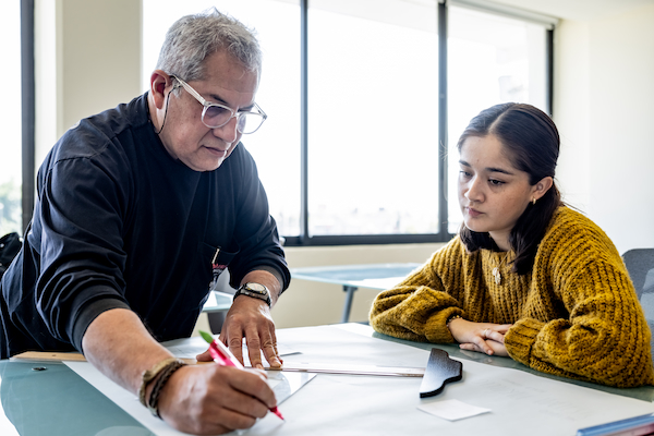 alumna de diseño con profesor en salon de clases