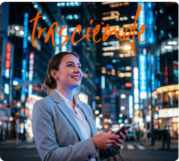 Joven profesionista sonriente utilizando su smartphone en un entorno urbano nocturno iluminado, con el texto superpuesto 'trasciende' de Posgrados Anáhuac.