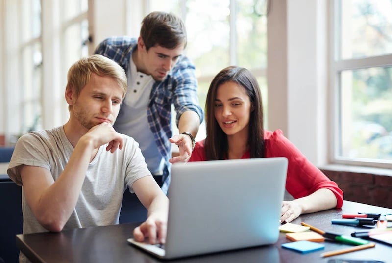 estudiantes de administración de empresas revisando la computadora