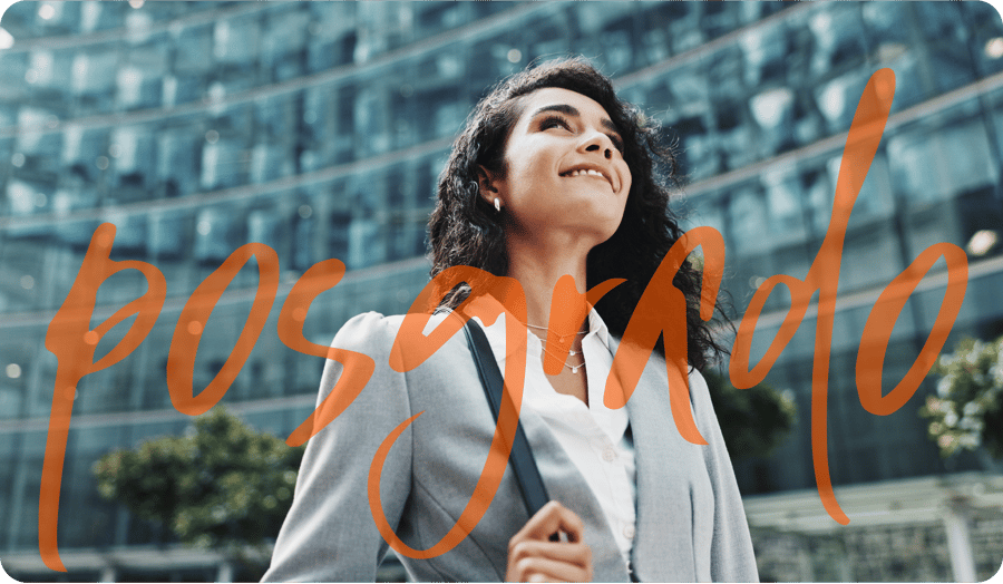 Mujer profesional con visión de éxito frente a un edificio corporativo moderno con el texto 'posgrado' en primer plano