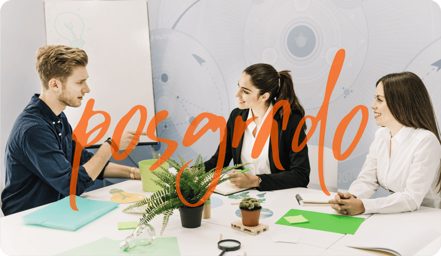 Tres profesionistas colaborando en una mesa de trabajo con materiales creativos y un pizarrón de ideas, bajo la palabra posgrado