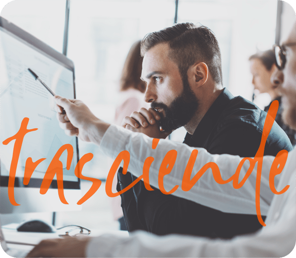 Equipo de profesionales analizando métricas y gráficos en un monitor de alta resolución, bajo el lema 'trasciende' de la comunidad Anáhuac