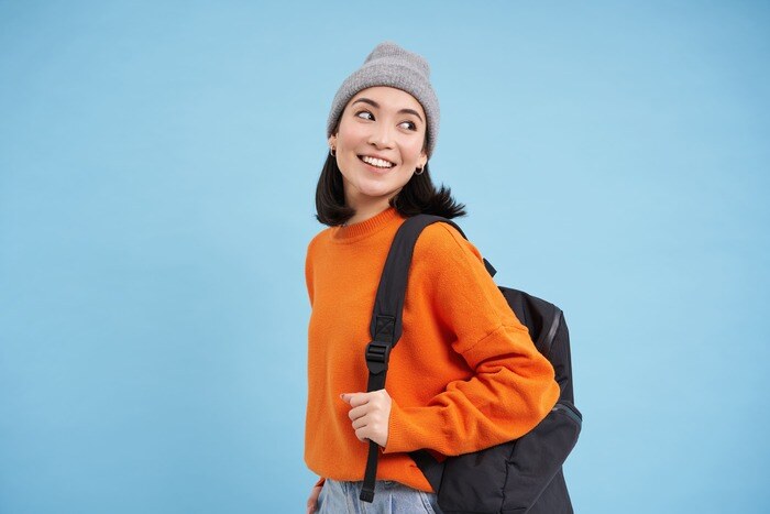 mujer con mochila fondo azul