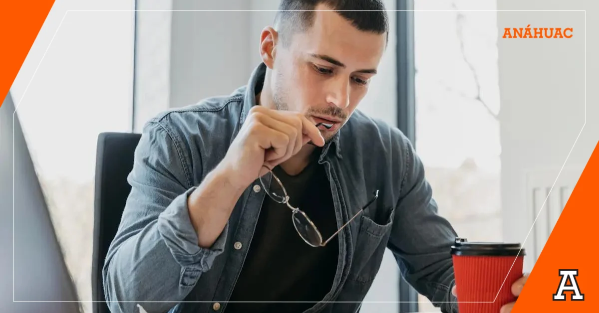 jóven estudiante mordiendo la punta de sus lentes mientras observa un plan de estudios