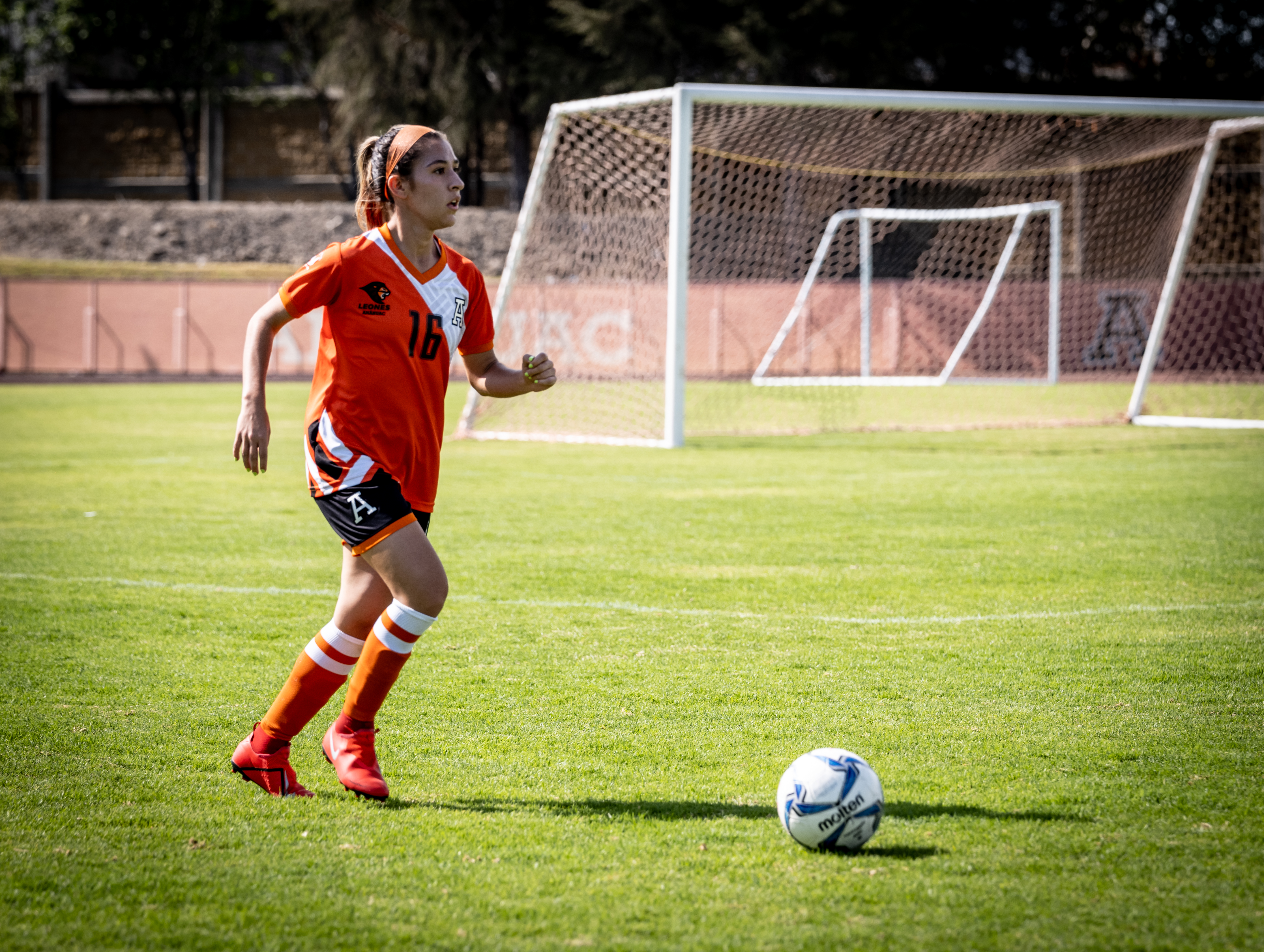 mujer a punto de patear un balón de fútbol