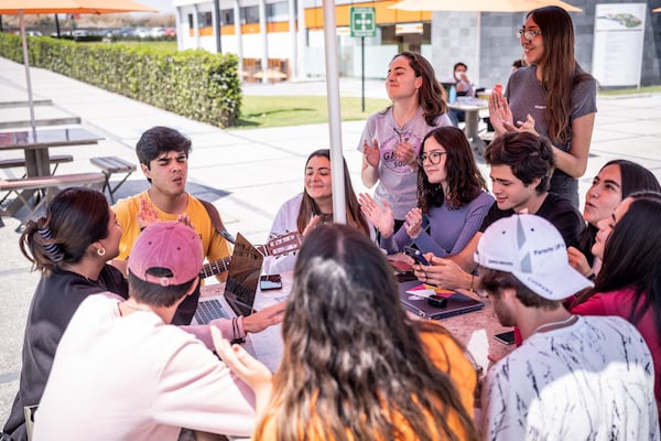 jóvenes cantando en una mesa