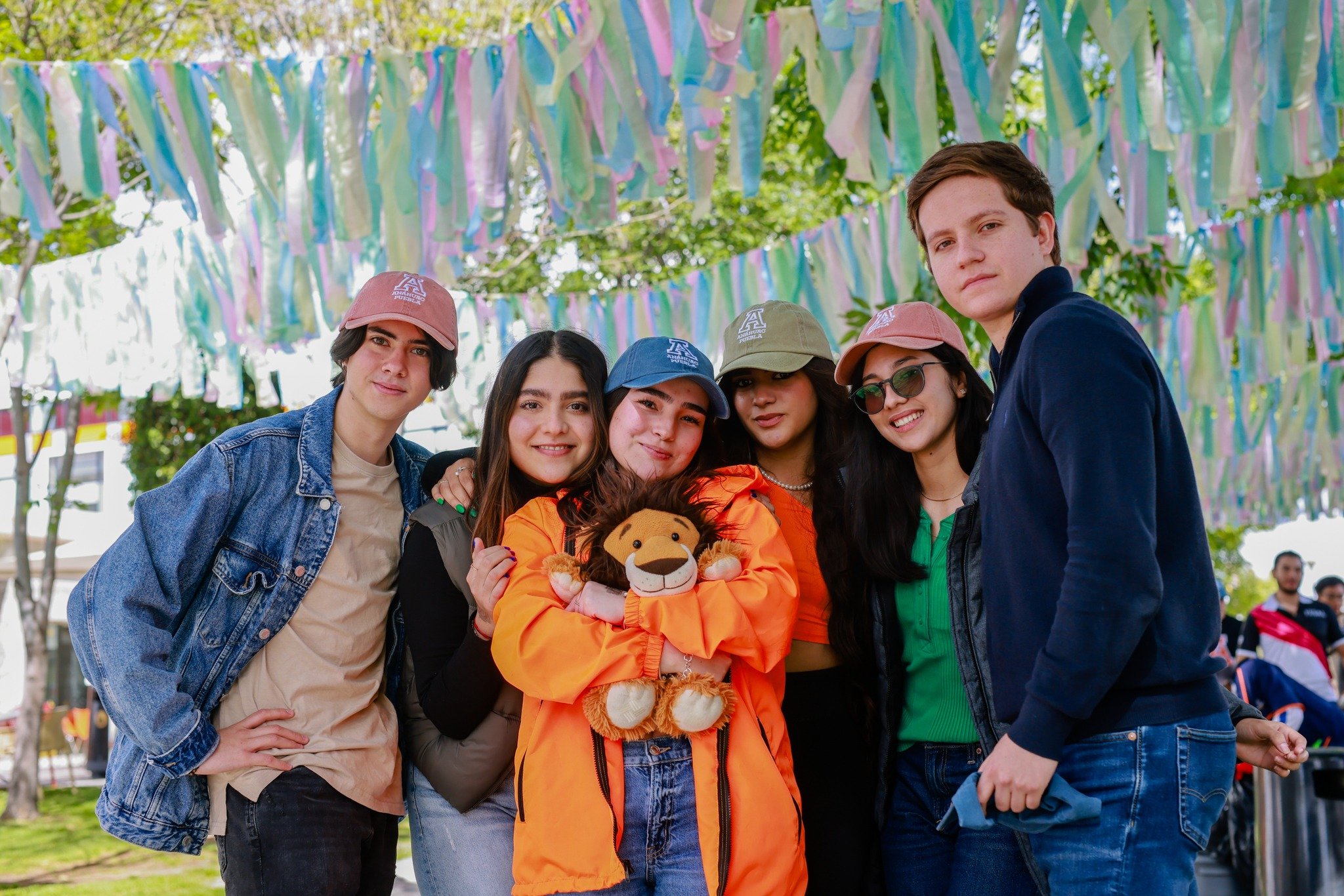 alumnos en evento social con peluche de la mascota UAP