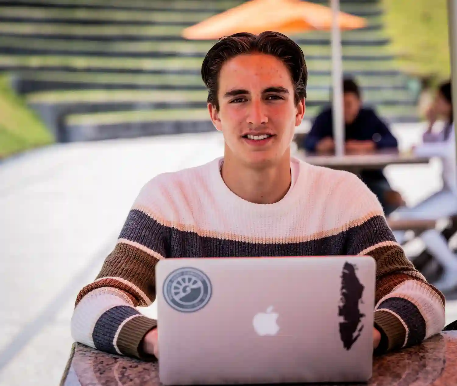 alumno con su computadora en una mesa de la UAP