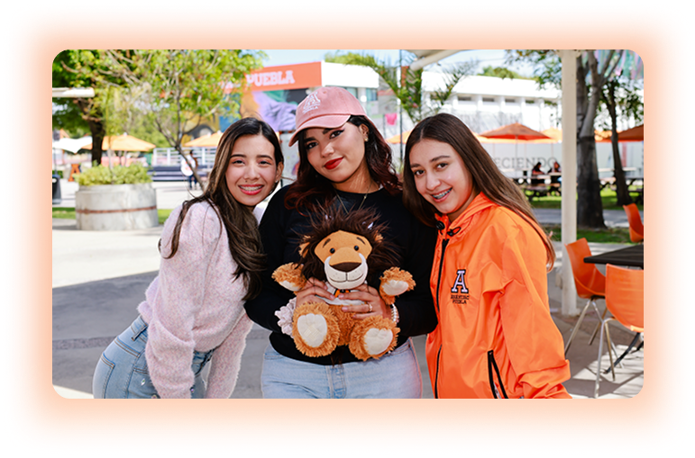 tres alumnas con peluche de la mascota de Anáhuac Puebla